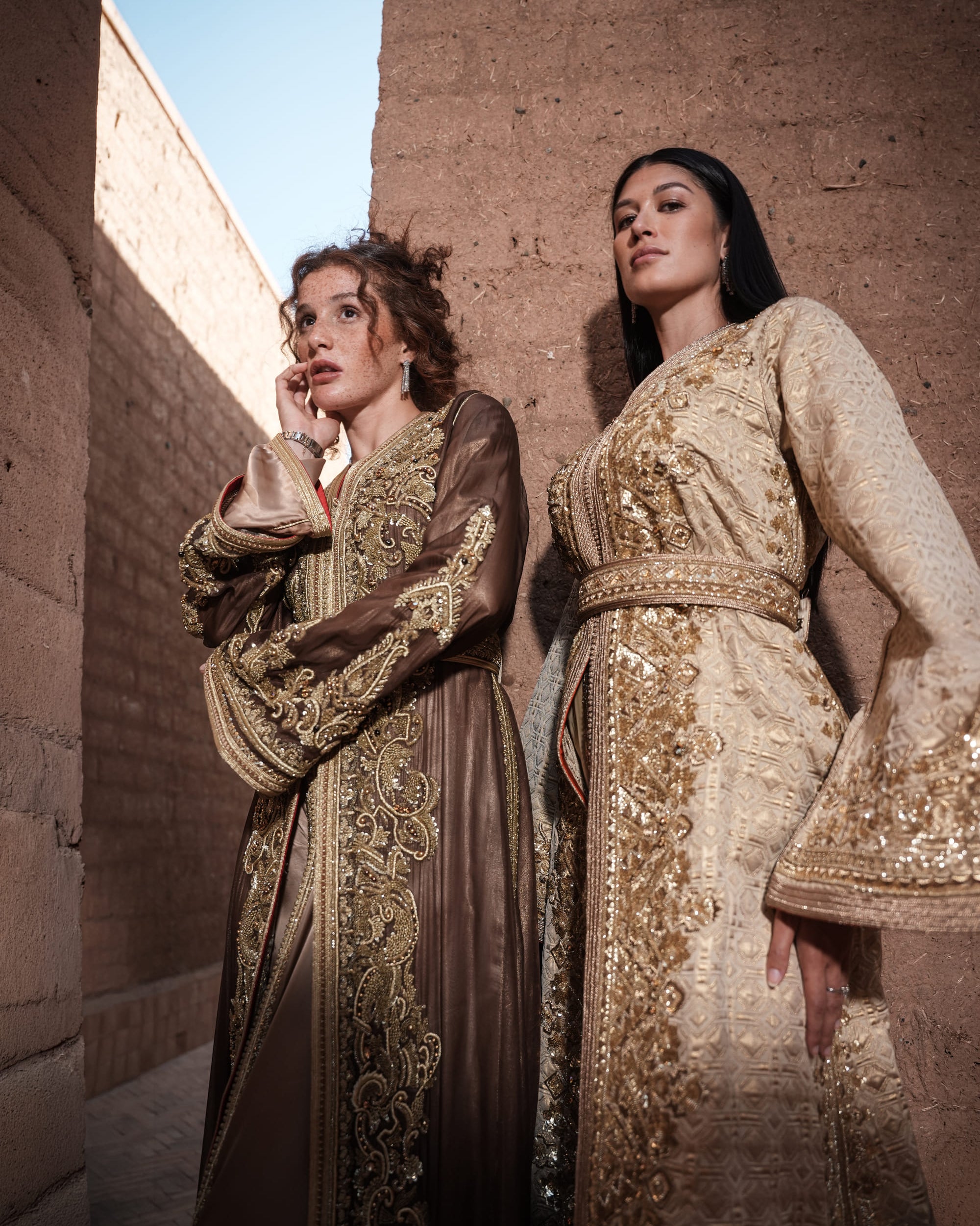 Alabaster Aria quilted ivory brocade Moroccan kaftan with gold sequin embroidery and belted waist, shown alongside a second look