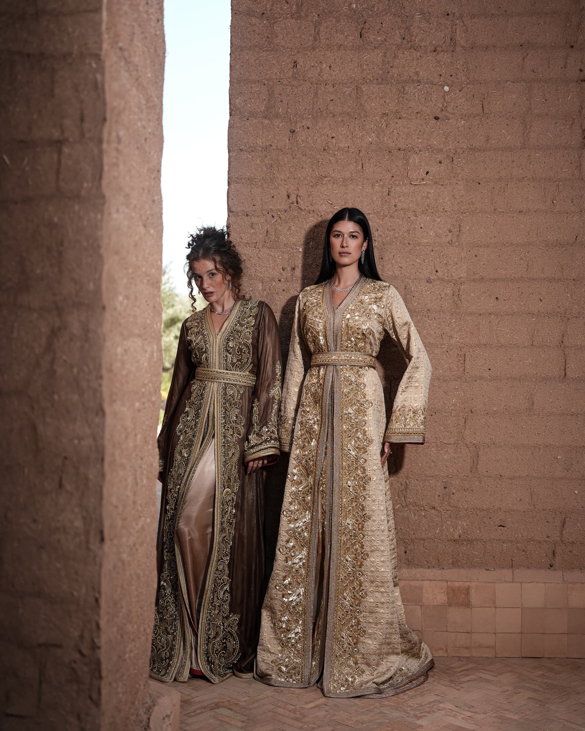 Alabaster Aria quilted ivory brocade Moroccan kaftan with gold sequin embroidery and belted waist, shown alongside a second look