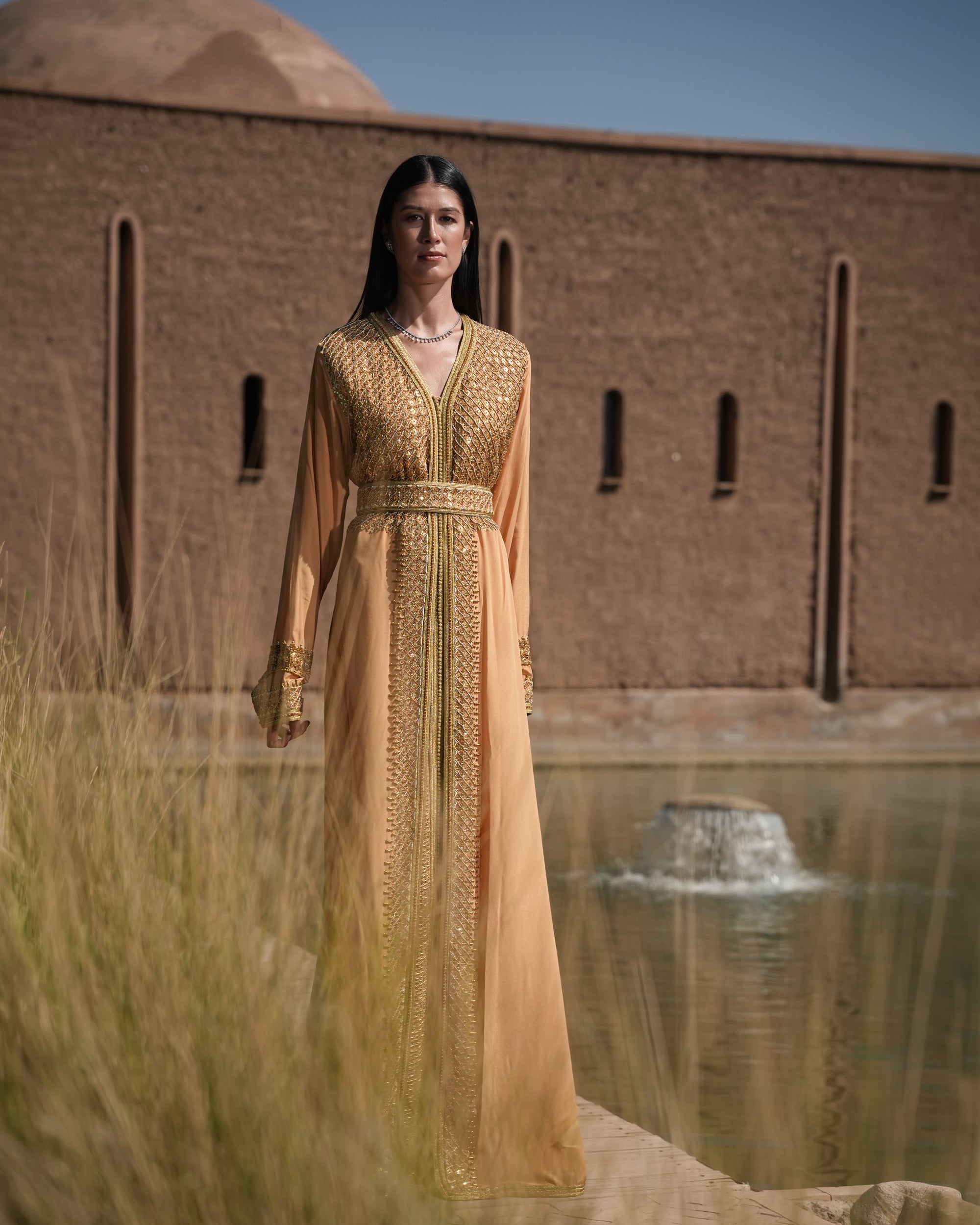 Amber Vigil apricot crepe Moroccan kaftan with a gold sequin mesh plastron at the neckline, full-length view