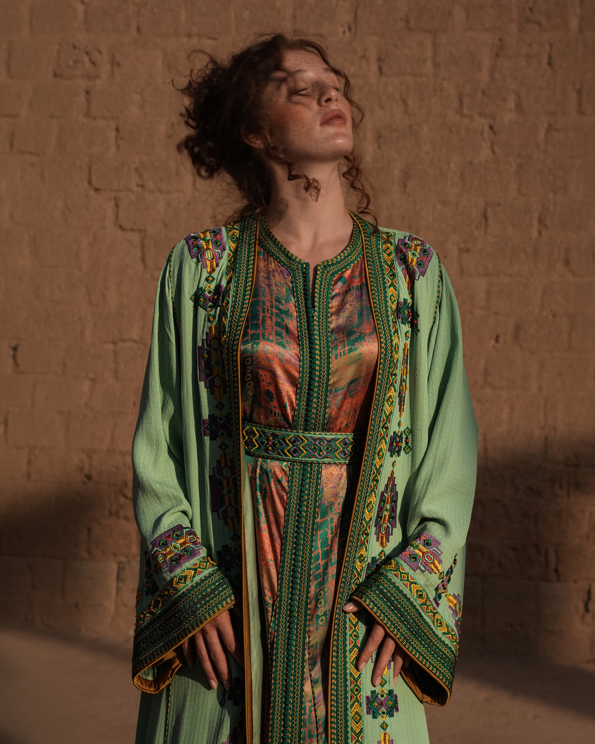 Anise Pavilion anise green Moroccan kaftan with Berber braid trims over a printed dress