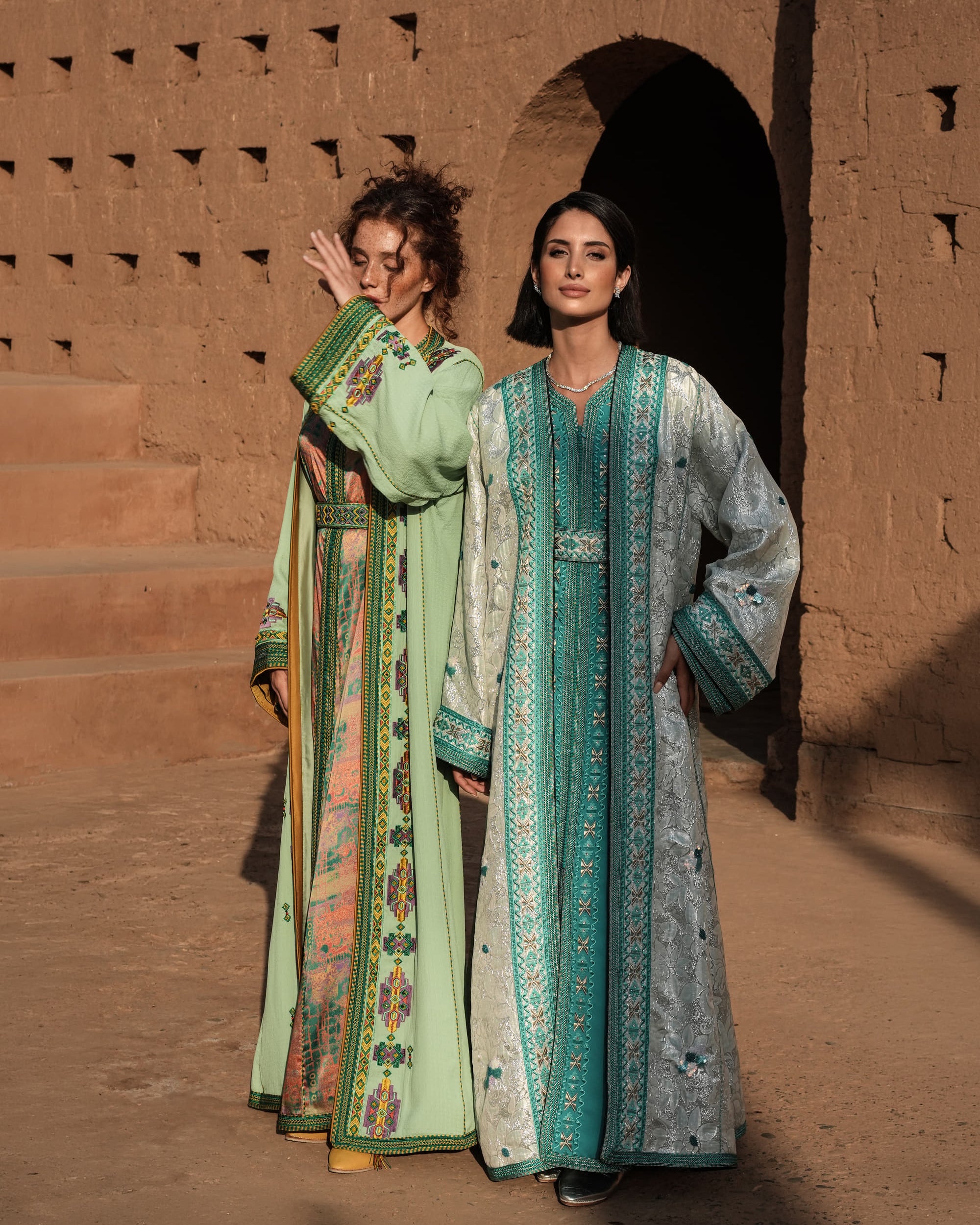 Anise Pavilion anise green Moroccan kaftan with Berber braid trims over a printed dress, shown alongside a second look