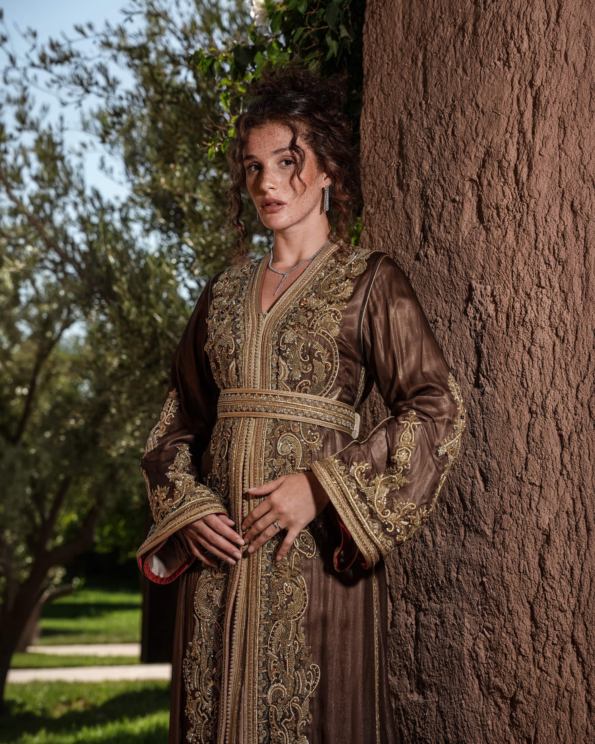 Bronze Reverie lamé organza Moroccan kaftan with gold embroidery, worn open over a champagne dress