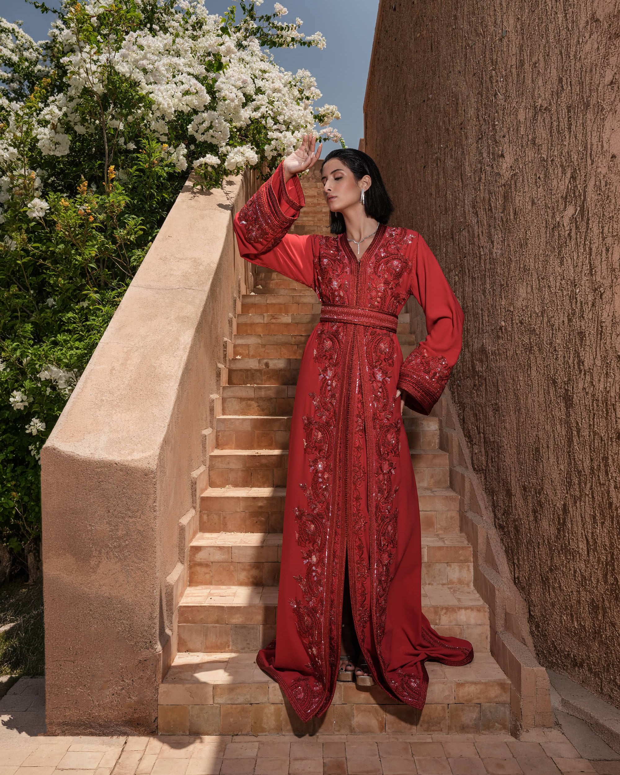 Carmine Cadence red crepe Moroccan kaftan with sequined paisley embroidery, braided belt and flared sleeves, full-length view