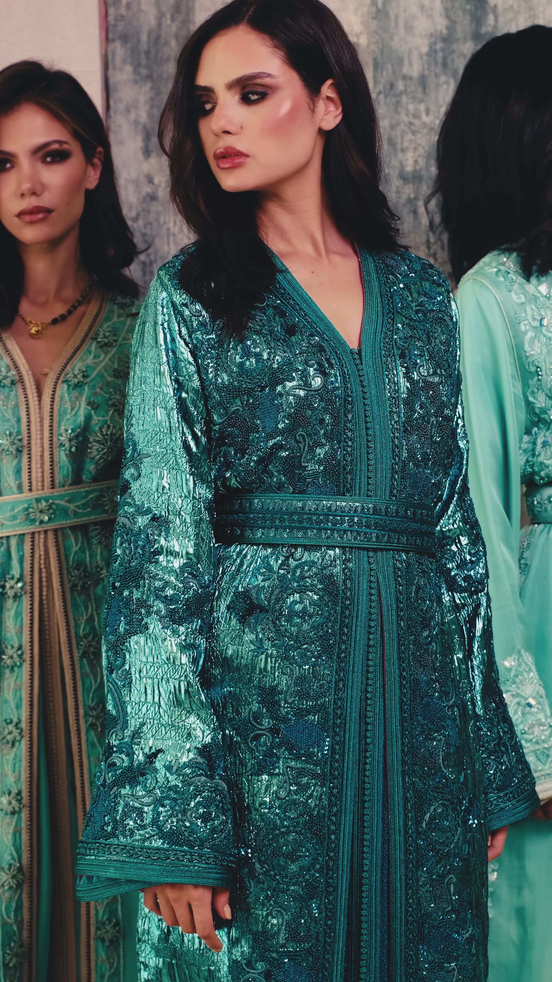 تفاصيل قفطان مغربي مزخرف من قماش البروشيه الأخضر، يُبرز جمال الحزام وتطريز الأكمام الغني مع لمسة بطانة وردية.