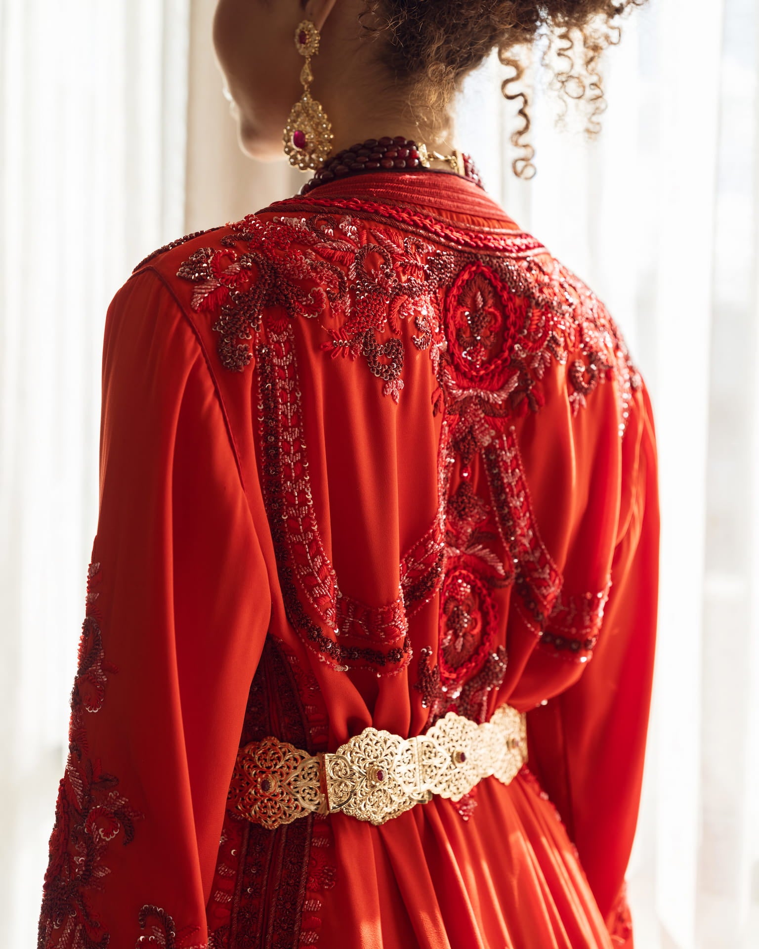 Deep ruby red couture Moroccan kaftan with gold embroidery, back view