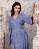Luxury Moroccan caftan in pastel lilac with hand-sewn detailing and refined finishing, modelled in a floral setting by Bouchra Filali Lahlou