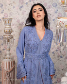 Artisanal lilac caftan with floral motifs and sparkling accents, designed by Bouchra Filali Lahlou, showcased in an elegant Moroccan interior