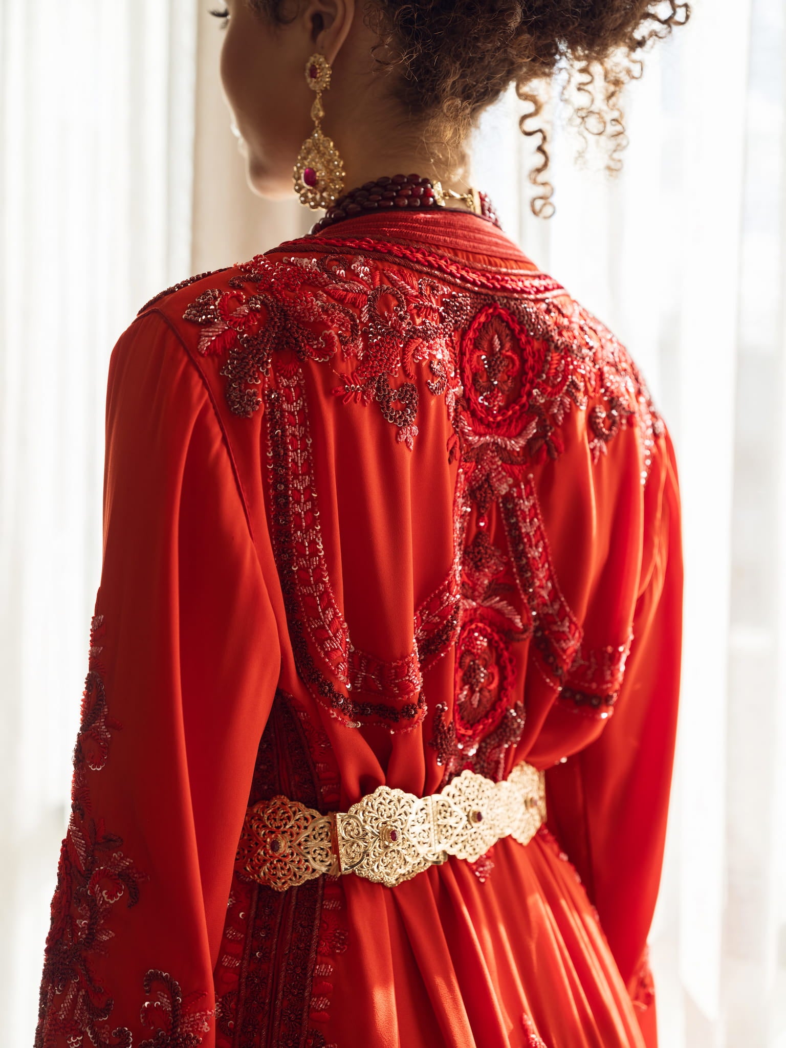 Deep ruby red couture Moroccan kaftan with gold embroidery, back view